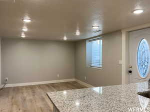 Entryway with wood-type flooring and a textured ceiling