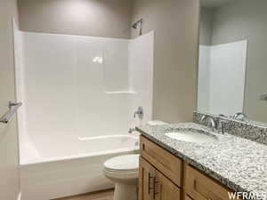 Full bathroom featuring tub / shower combination, hardwood / wood-style floors, toilet, and vanity