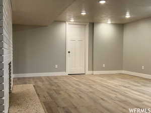 Basement featuring light hardwood / wood-style flooring and a textured ceiling