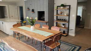 Dining space with light hardwood / wood-style floors and a fireplace