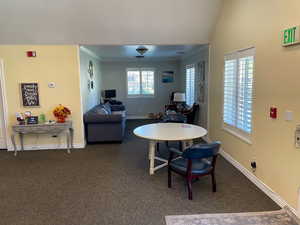 Dining area featuring ornamental molding, dark carpet, and ceiling fan