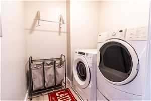 Clothes washing area with washing machine and clothes dryer and wood-type flooring