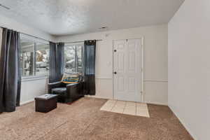 Entryway with a textured ceiling and light carpet