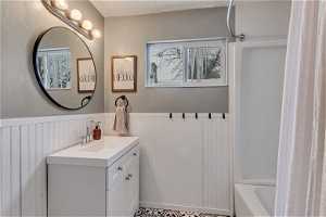Bathroom with shower / tub combo with curtain, a healthy amount of sunlight, and vanity