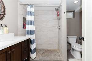 Bathroom with vanity, toilet, tile flooring, and walk in shower