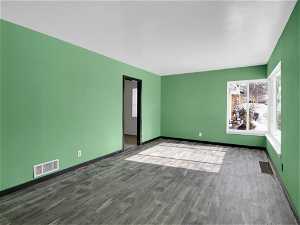 Unfurnished room with dark hardwood / wood-style flooring.