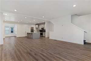 Unfurnished living room featuring sink and dark hardwood / wood-style floors