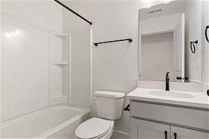 Full bathroom with toilet, vanity with extensive cabinet space, and shower / washtub combination