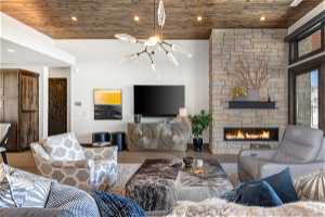 Living room with a chandelier, light hardwood / wood-style flooring, wooden ceiling, and a fireplace