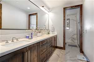 Bathroom with tile floors, double vanity, and walk in shower