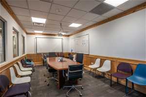 Carpeted office featuring ornamental molding and a drop ceiling