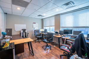 Office with dark wood-type flooring and a paneled ceiling