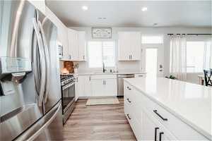 Kitchen featuring white cabinetry, sink, appliances with stainless steel finishes, and plenty of natural light