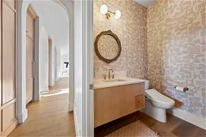 Bathroom featuring hardwood / wood-style floors, toilet, and vanity