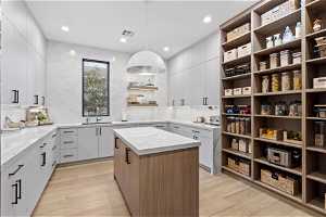 Kitchen with white cabinets, hanging light fixtures, and backsplash