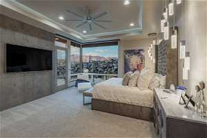 Bedroom with access to exterior, a raised ceiling, light carpet, and ceiling fan