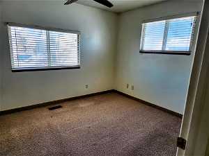 Unfurnished room featuring carpet floors and ceiling fan