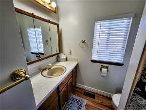 Bathroom featuring oversized vanity, toilet, and hardwood / wood-style flooring