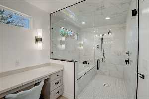 Bathroom featuring plenty of natural light, vanity, and shower with separate bathtub