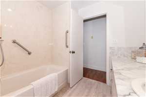 Bathroom with vanity,  shower combination, and hardwood / wood-style floors