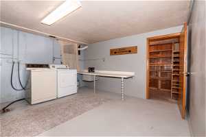 Laundry room featuring independent washer and dryer, a textured ceiling, and washer hookup
