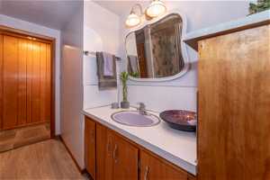 Bathroom featuring vanity, a textured ceiling, and hardwood / wood-style floors