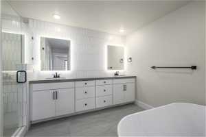 Bathroom with tile floors, dual bowl vanity, and plus walk in shower