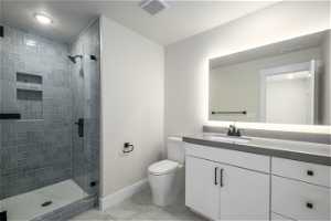 Bathroom featuring oversized vanity, toilet, tile flooring, and walk in shower