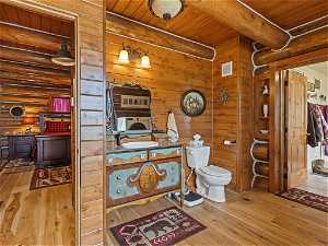 Bathroom with toilet, wood ceiling, beam ceiling, and hardwood / wood-style flooring