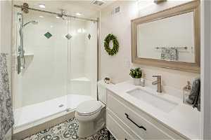 Bathroom featuring oversized vanity, toilet, tile flooring, and an enclosed shower