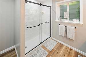 Bathroom with hardwood / wood-style floors and an enclosed shower