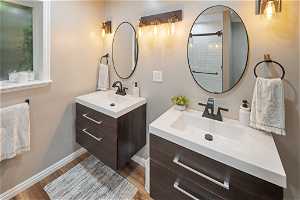 Bathroom featuring large vanity, double sink, and hardwood / wood-style flooring