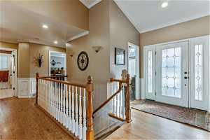 Foyer featuring ornamental molding, hardwood floors and high vaulted ceilings