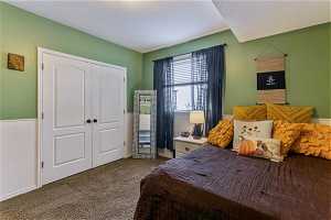 Bedroom with walk-in closet and dark carpet
