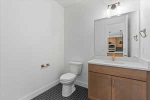 Bathroom with vanity, toilet, and tile patterned floors