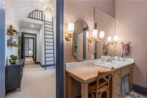 Bathroom featuring vanity and high vaulted ceiling