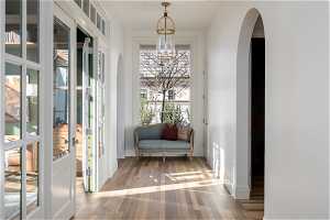 Living area with light hardwood / wood-style flooring and french doors