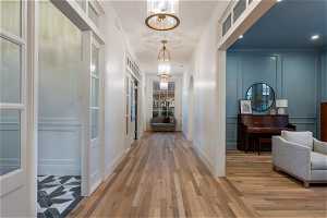 Hall featuring a chandelier and light hardwood / wood-style flooring