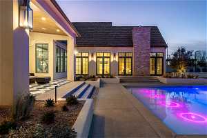 Pool at dusk with a patio and french doors