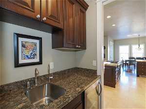 Butlers pantry with sink, granite counter and beverage cooler