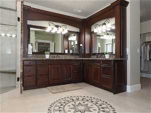 Primary Suite Bathroom with double sink and rich dark cabinetry
