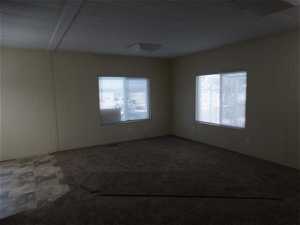 Carpeted empty room with beamed ceiling