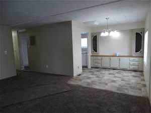 Spare room with light carpet and a notable chandelier