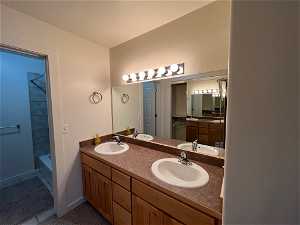 Bathroom with large vanity, shower / bath combination, and dual sinks