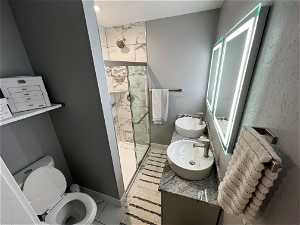 Bathroom featuring tile floors, vanity, toilet, and an enclosed shower