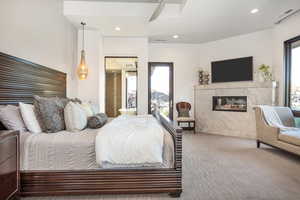 Bedroom with multiple windows, a fireplace, light colored carpet, and ceiling fan