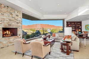 Living room with a stone fireplace, light tile flooring, and a mountain view