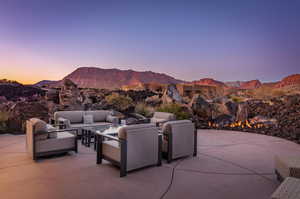 Patio terrace at dusk with an outdoor hangout area and a mountain view