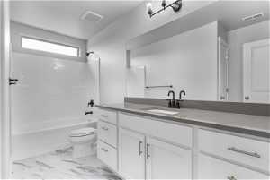 Full bathroom with toilet, tile floors, vanity, and shower / tub combination