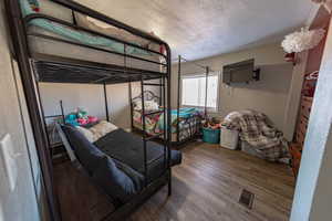 Bedroom featuring dark hardwood / wood-style floors and a textured ceiling